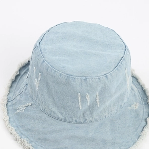 Detail shot of light blue denim bucket hat featuring frayed edges and distressed texture