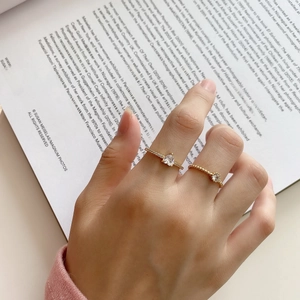 Close-up of gold 925 sterling silver stacking rings with zircon stones on a model hand