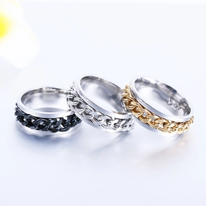 Vue détaillée de trois bagues spinner de 6 mm en acier inoxydable noir, argent et or