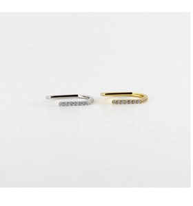 Macro detail of U-shaped gold and silver ear cuffs with pavé-set zircon stone accents