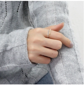 Close-up of minimalist S925 silver wrap ring with micro-pave crystals on knit fabric
