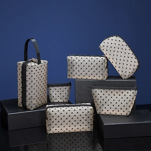 Detailed set of six beige mesh makeup bags with black heart prints on studio pedestals