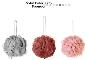 Macro detail of soft PE mesh bath sponges in grey, brown and pink with hanging ropes