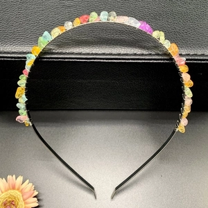 Macro detail of handmade colorful natural crystal stones wired on a black crown headband