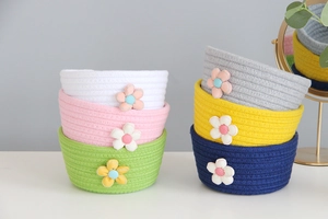 Detailed stack of colorful cotton rope baskets with floral accents for home organization