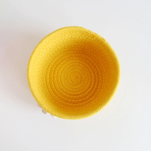 Top view of yellow cotton rope woven basket showing interior spiral texture