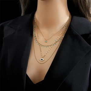 Multi-layer gold vintage necklace with turquoise pendant and eye charm on female model