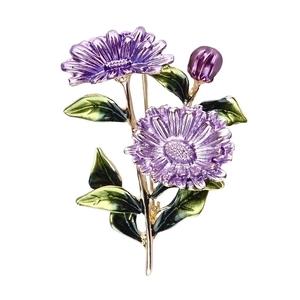 Elegant purple enamel flower brooch with green leaves and golden stem on white background
