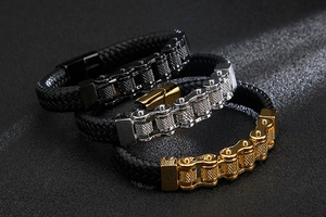 Close-up of men's leather bracelets with chain links in black, gold, and silver finishes