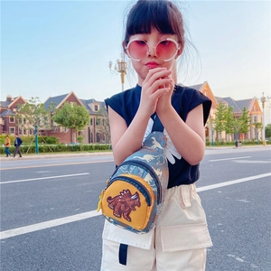 Detail of cute dinosaur kids chest bag showing cartoon embroidery and yellow pocket zip