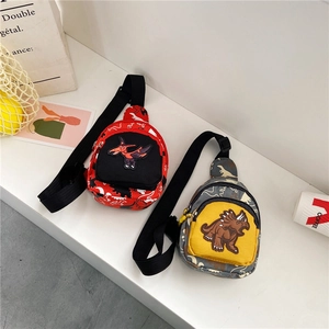 Detail view of red and camouflage canvas dinosaur chest bags for kids in a stylish setting
