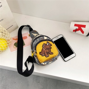 Detail of gray camo kids dinosaur chest bag with a yellow front pocket and 3D dinosaur spikes