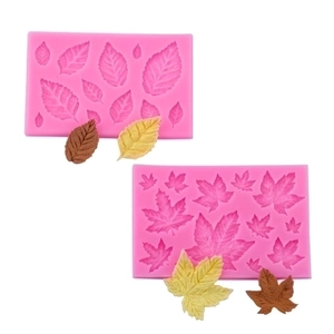 Pink silicone leaf molds set with brown and green fondant leaf shapes on white background