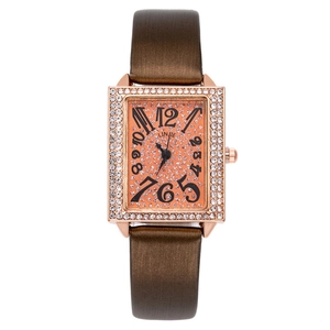 Detail of rose gold tonneau watch with orange diamond dial and crystal bezel