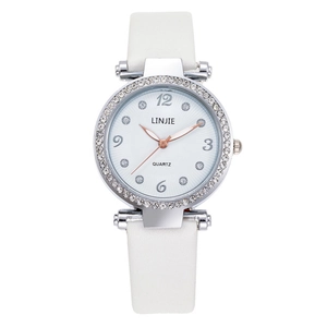 Detailed close-up of square barrel watch dial with rhinestone bezel and white leather strap