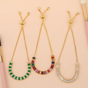 Detail of adjustable gold bolo bracelets with baguette-cut crystal stones and slider clasp