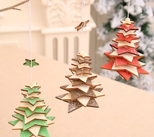 Detailed view of three hanging wooden Christmas tree ornaments with white snow-effect edges