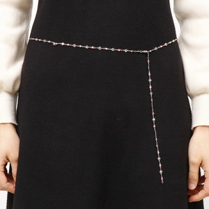 Chaîne de taille argentée minimaliste avec yeux bleus et cœurs sur une robe noire