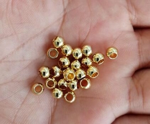 Gros plan de perles creuses en acier inoxydable doré pour la création de bijoux