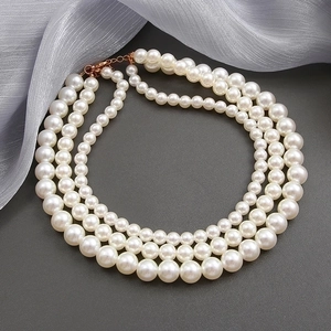 Three-layer faux pearl necklace with elegant triple-strand design and gold lobster clasp