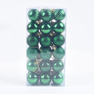 Detail of green Christmas balls in various finishes like matte and glitter in a box