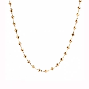 Detail showing the interconnected golden heart shaped links of a minimalist necklace