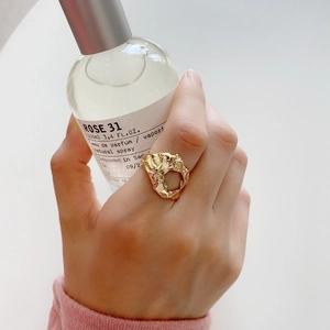 Detailed view of an irregular hollow gold-plated ring featuring artistic lava texture