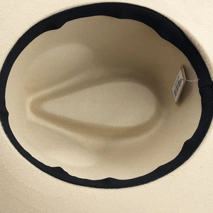 Close-up of beige wool fedora interior with black sweatband and product tag detail