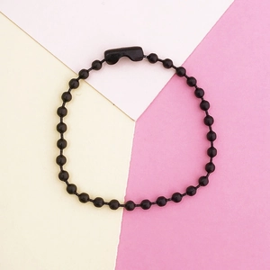 Macro detail of a black 2.4mm bead chain with secure connector over a modern backdrop