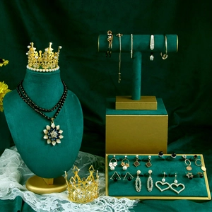 Exquisite gold and black jewelry set on dark green velvet display with floral accents