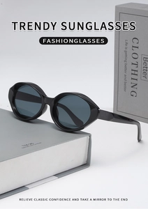 Detail shot of vintage cat-eye sunglasses with thick black oval frames on a book