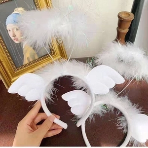 Close-up of white glowing angel halo headband with soft feathers and decorative wings