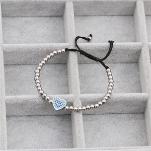 Detailed close-up of woven bead bracelet with micro-paved blue zircon heart charm