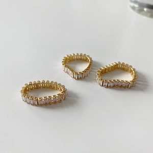 Macro view of three gold rings with rectangular zircon stones in a tiered setting