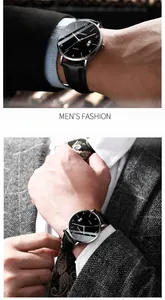 Close-up of thin men's quartz watch with black dial and leather strap worn with a grey suit