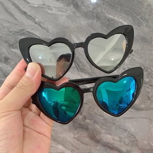 Détail de lunettes de soleil coeur pour enfants avec monture noire et verres miroir