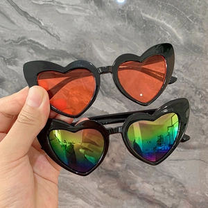 Gros plan de lunettes de soleil en forme de cœur avec monture noire et verres rouges