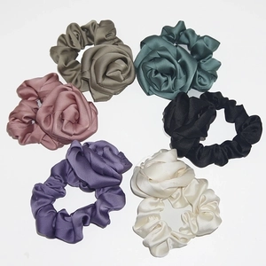 Detail of silk rose scrunchies in six elegant colors including khaki, green and pink