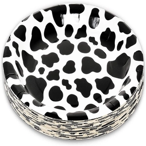Stack of round paper plates with black and white cow print for farm theme party decoration