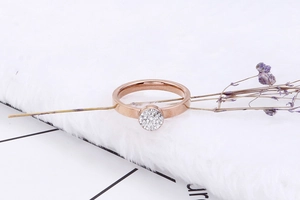 Détail d'une bague en or rose avec cristaux pavés sur un tissu en peluche blanc