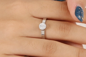 Détail d'une bague argentée avec cristaux pavés ronds portée sur le doigt chic