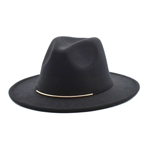 Détail d'un chapeau fedora en laine noire avec une élégante bande métallique dorée fine