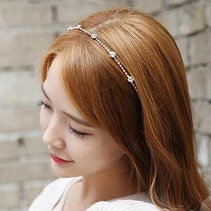 Détail d'un serre-tête fin en cristal avec strass et chaîne en métal argenté sur cheveux