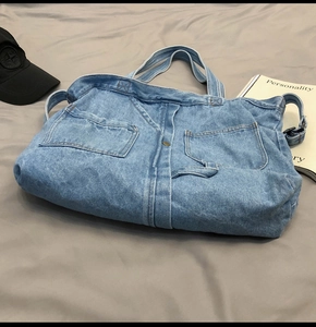 Detail of vintage denim tote bag with patchwork design and external pockets for casual style