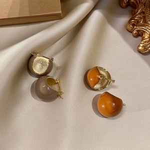 Detail of vintage wide hoop earrings in taupe and caramel resin with gold metal texture