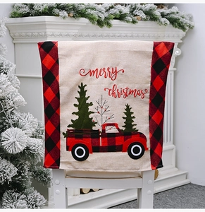 Close-up of red plaid Christmas chair cover with truck embroidery and pine tree decor