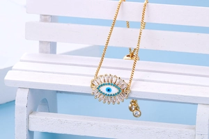 Detailopname van de gouden evil eye-armband met blauw midden en witte zirkonia-stenen