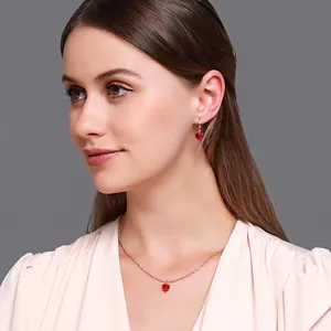 Parure de bijoux élégante avec collier et boucles d'oreilles cœur rouge sur un mannequin
