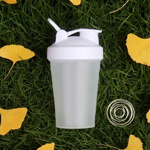 Detail of portable shaker bottle with whisk ball on autumn grass for protein shakes