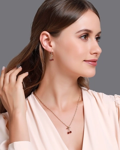 Détail du collier pendentif cerise rouge et boucles d'oreilles en cristal sur un mannequin